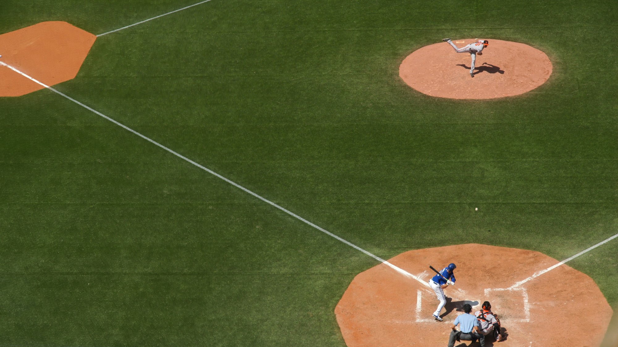 Aerial view of a baseball game in progress — pitcher on the mound, batter at the plate